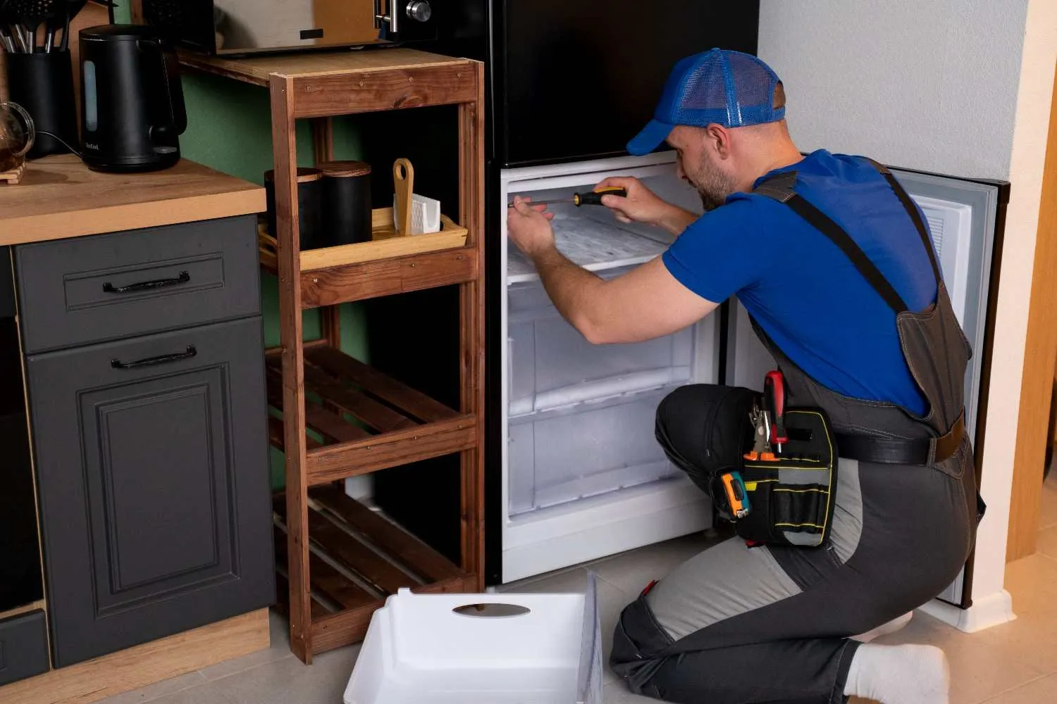 Technician repairing the freezer drawer of a refrigerator